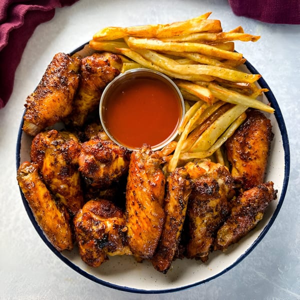 Fresh Horses Saloon's crispy chicken wings and golden french fries with a side of dipping sauce.